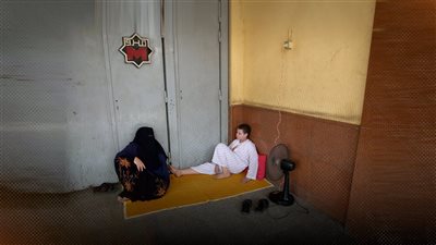 سيدة وابنها على الرصيف يكشفان المعاناة من انقطاع الكهرباء في الجيزة 